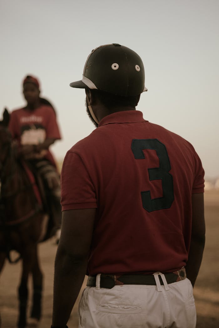 A polo player in a red jersey stands on the field ready for action, capturing the essence of the sport.